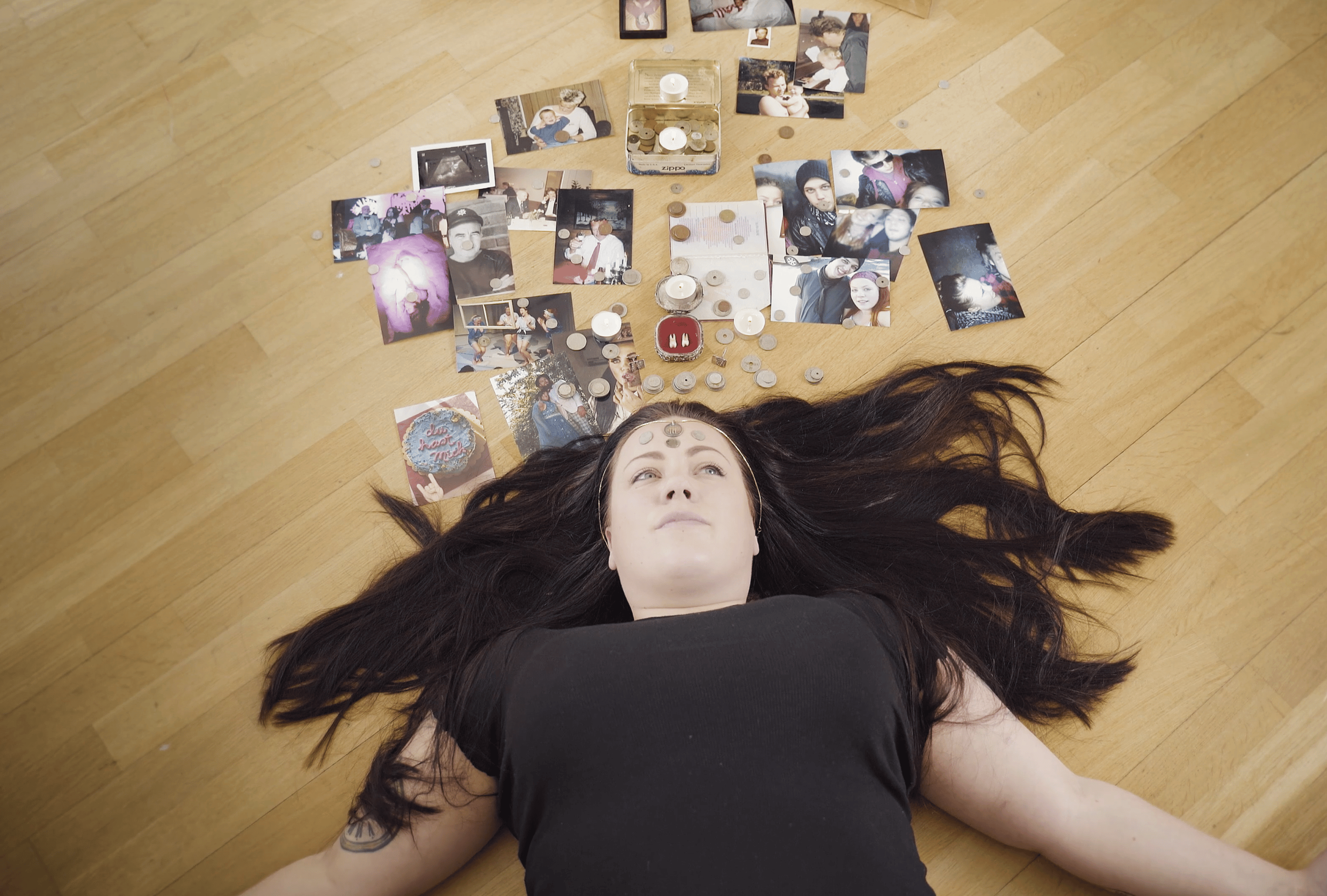 Bilde av Kaisa Hansen-Suckow som ligger på gulvet med penger og eiendeler rundt seg
