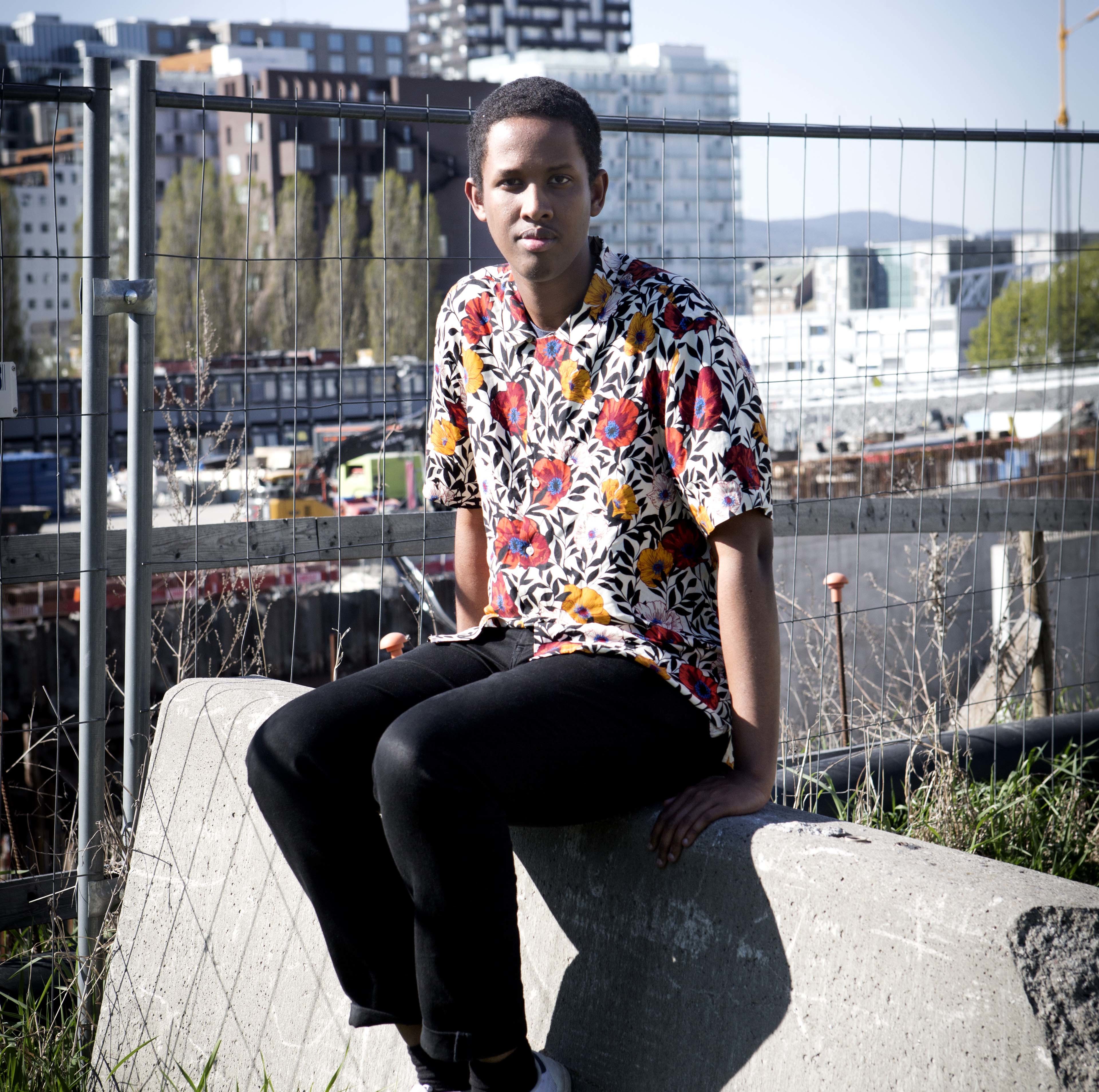 Bilde av Abdirahman Hassan foran byggeplass i Oslo sentrum